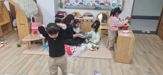 아이들 곁에서 사랑을 전하는 자원봉사자 사진